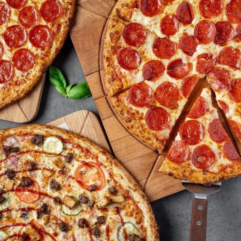 Three pizzas on wooden boards from Sariq Bola Pizza